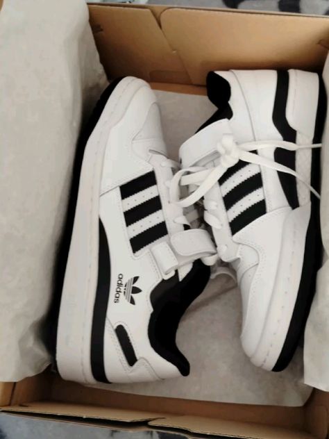 Side profile of the Adidas Forum Low White and Black, highlighting its Three Stripes branding, cushioned midsole, and retro-inspired silhouette.
