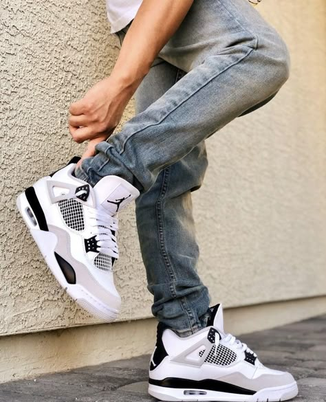 Air Jordan 4 White and Black (Retro Military Black) worn on feet, emphasizing its bold style, comfort, and timeless Jordan heritage.

