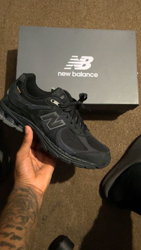 Side profile of the New Balance 2002R Black, highlighting its cushioned midsole, durable outsole, and sleek all-black design.

